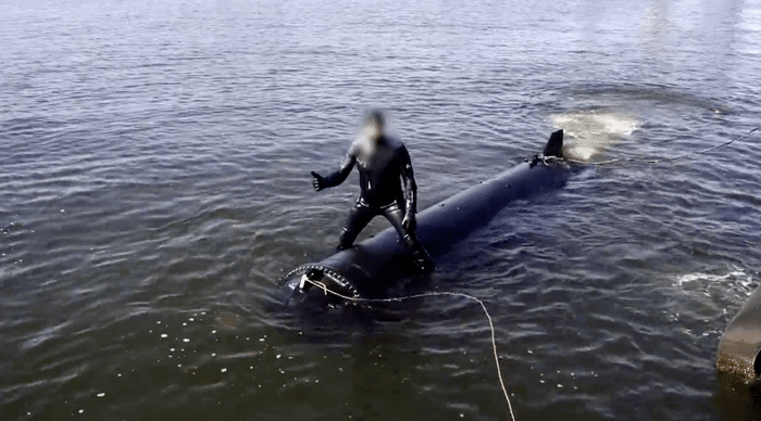 photo of the Marichka underwater drone with a diver sitting on it during sea trials